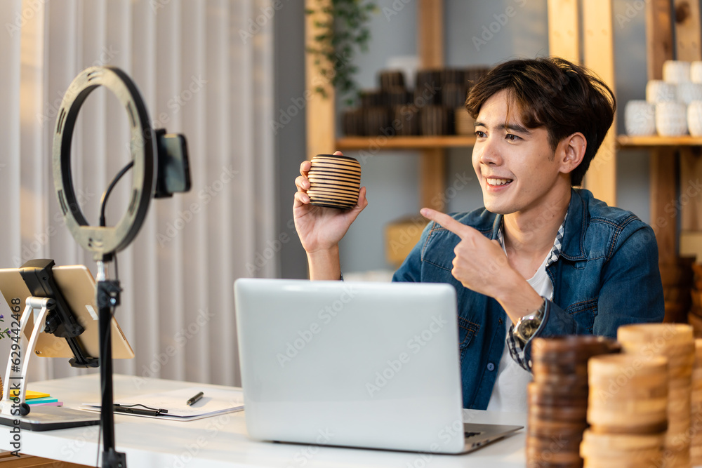 Asian handsome man sell vase product online live streaming at home. 