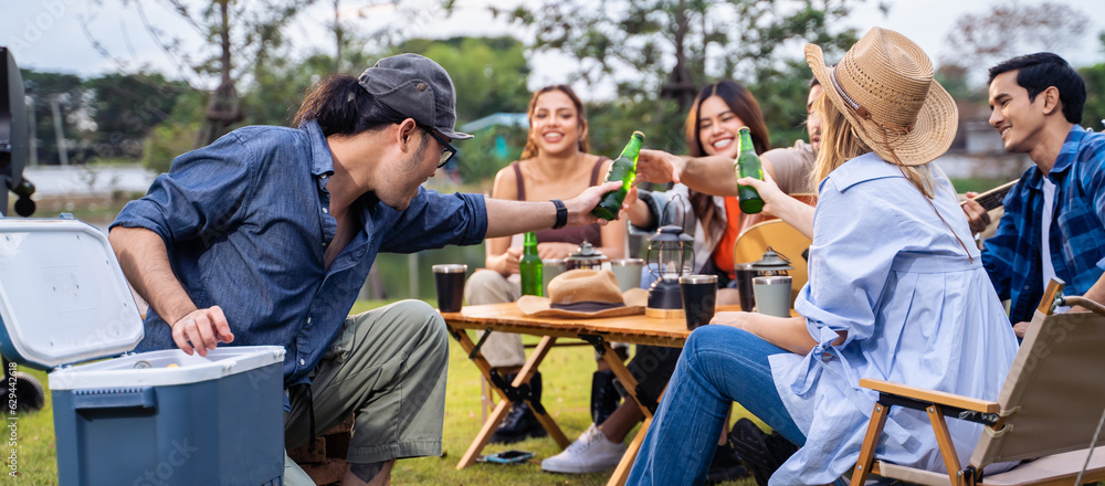 Group of diverse friend having outdoors camping party together in tent. 