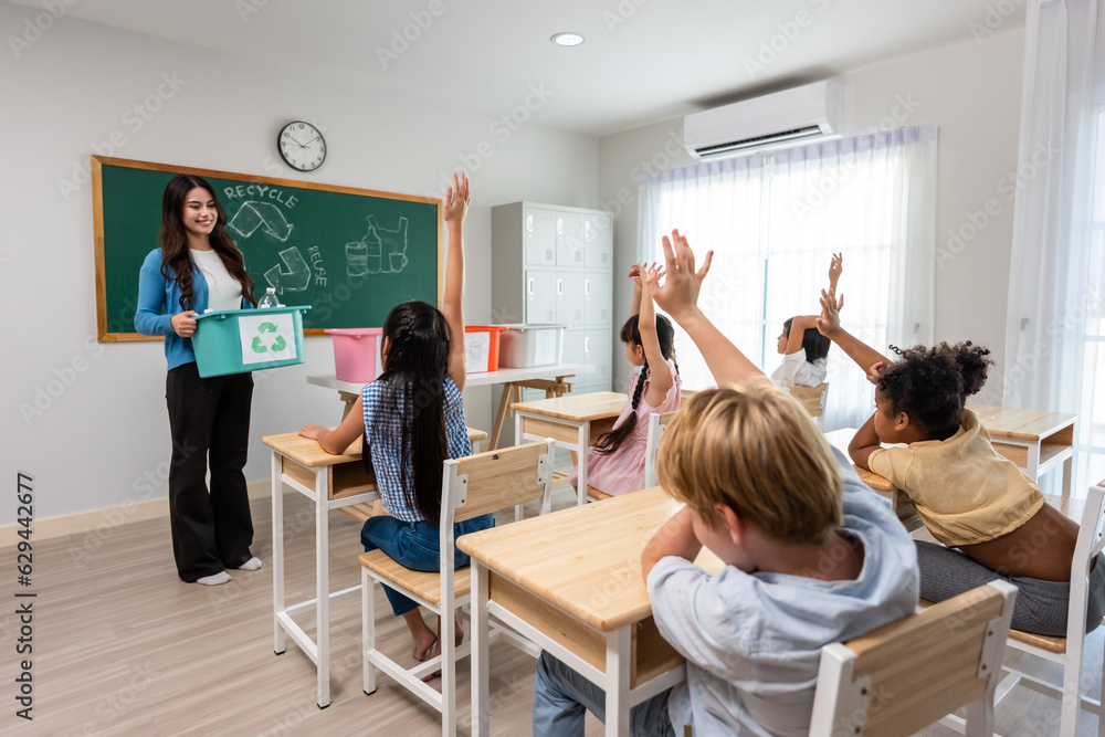 Group of student learn with teacher in classroom at elementary school. Attractive beautiful female i