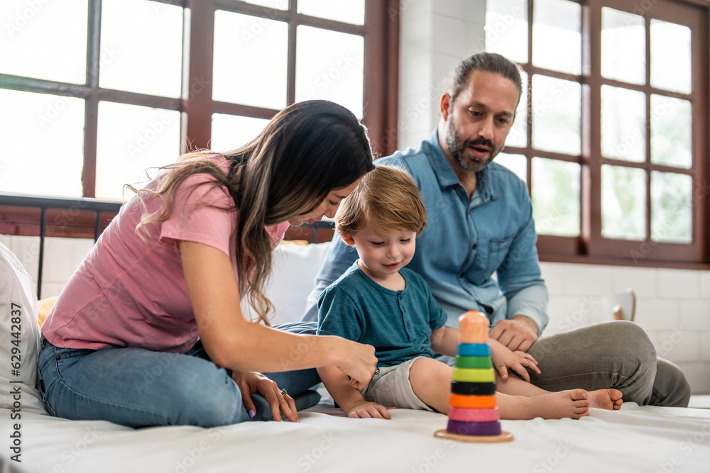 Caucasian family spend leisure time with baby boy in bedroom at house. 