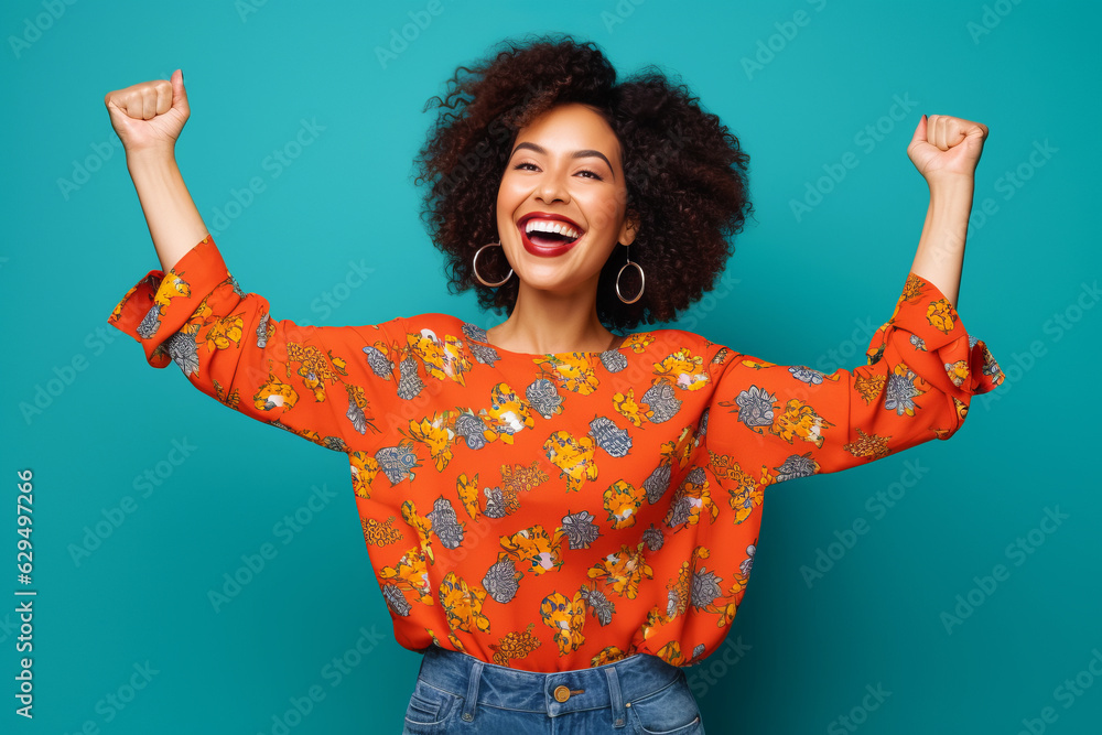 Woman with afro is smiling and raising her arms in the air.