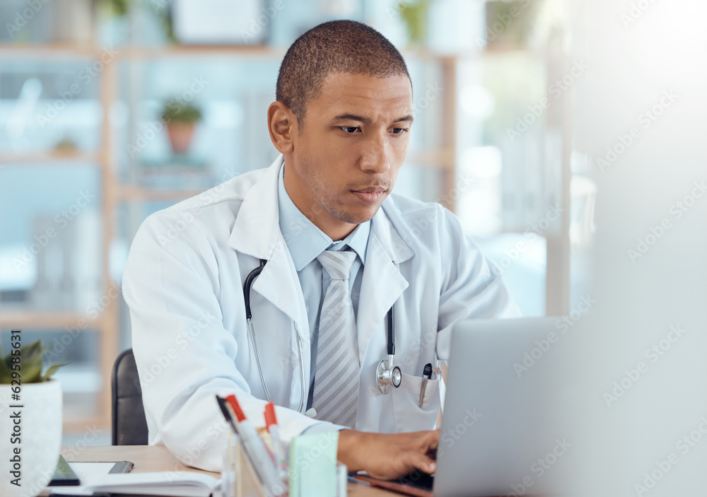 Doctor, man and typing on laptop in clinic for hospital management, healthcare research and teleheal