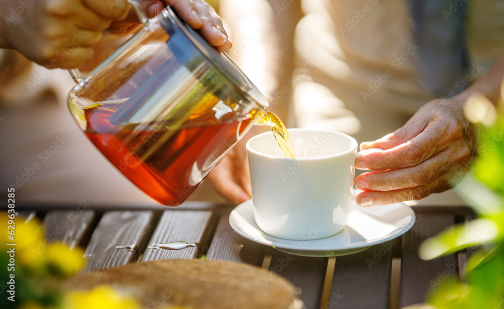 Pouring black tea into glass cup