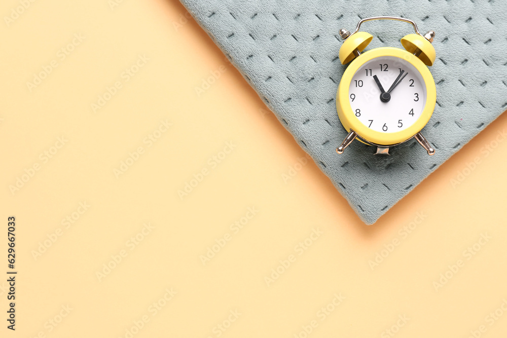 Notebook and alarm clock on color background