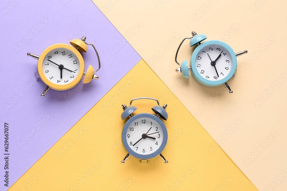 Vintage alarm clocks on color background