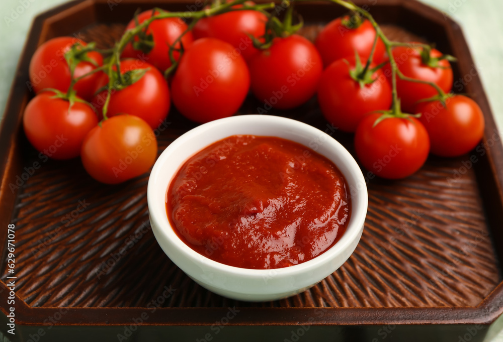 Bowl with tasty tomato paste on table