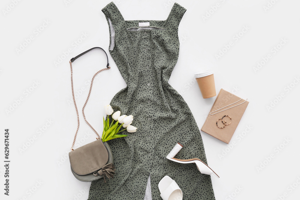 Stylish dress with accessories, shoes, book, tulips and cup of coffee on white background