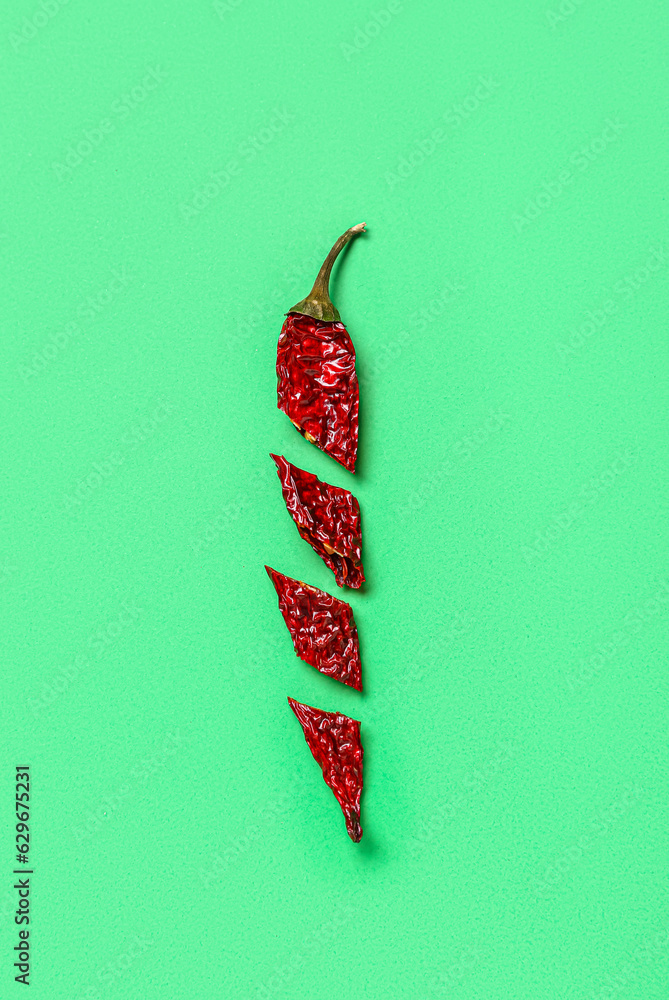 Cut chili pepper on green background