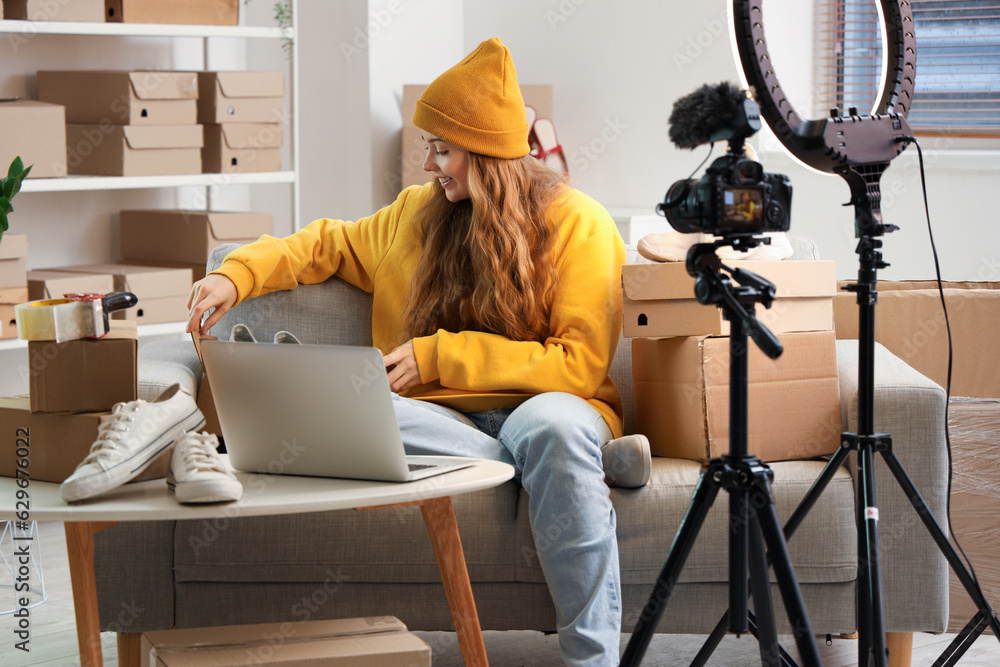 Female seller with shoes recording video at home