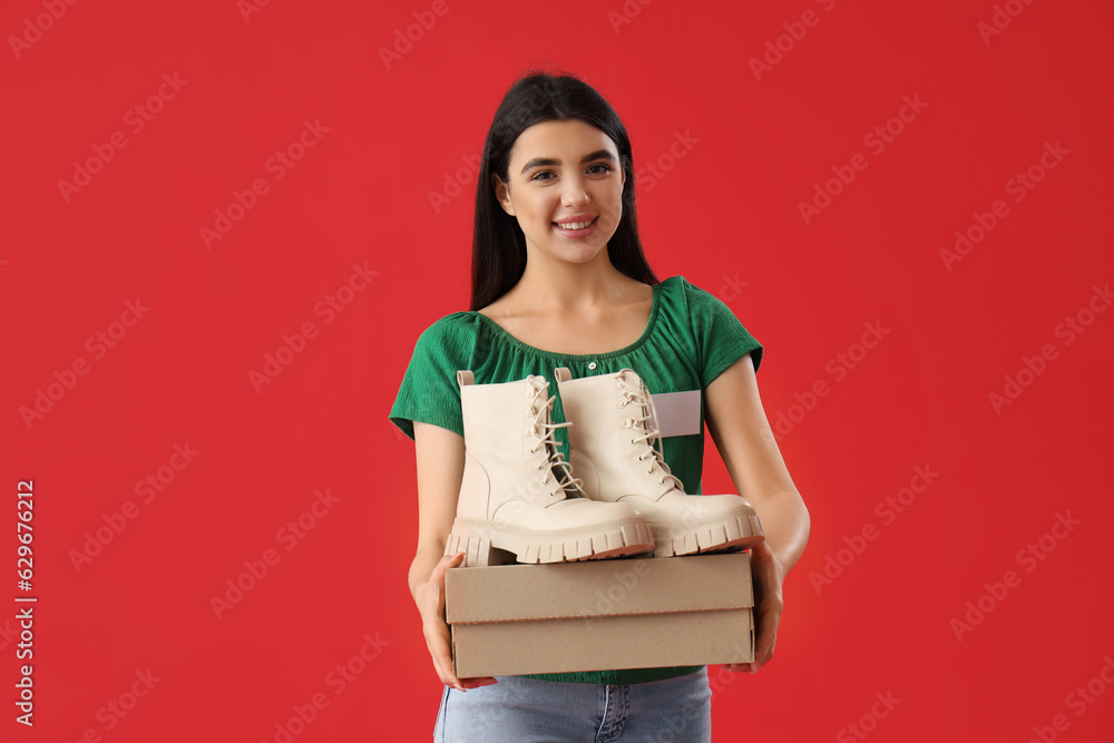 Female seller with stylish boots on red background