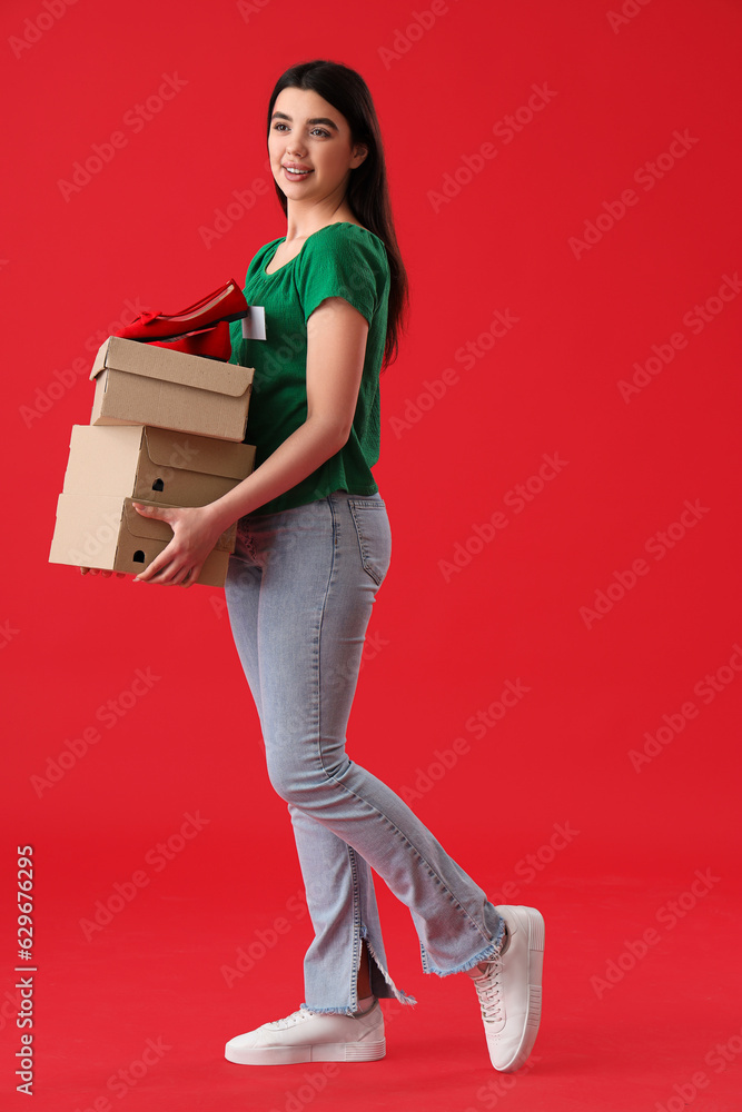 Female seller with shoe boxes on red background