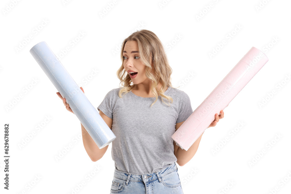 Surprised young woman with wallpaper rolls on white background