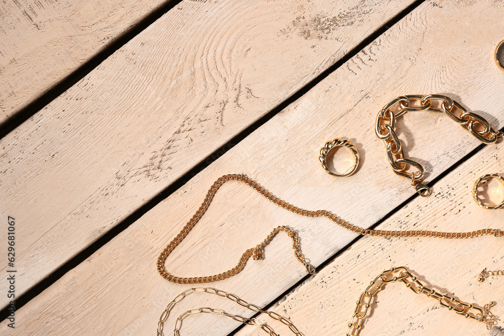 Beautiful golden jewellery on wooden background