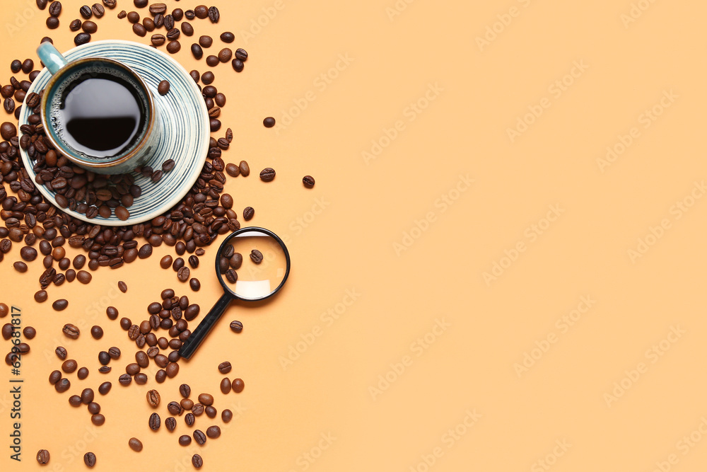 Magnifier and cup of coffee with beans on pale orange background