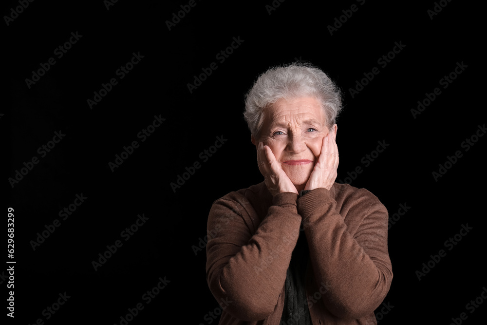 Senior woman on black background