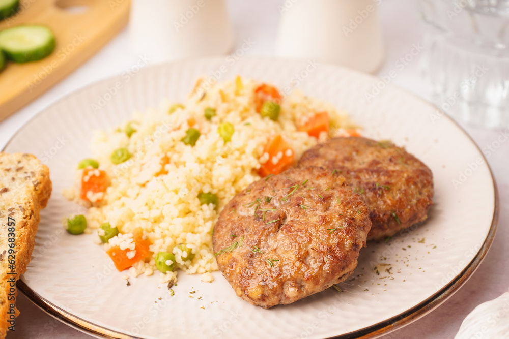 Cutlets with bulgur and boiled vegetables on light table in kitchen