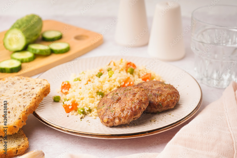 Cutlets with bulgur and boiled vegetables on light table in kitchen