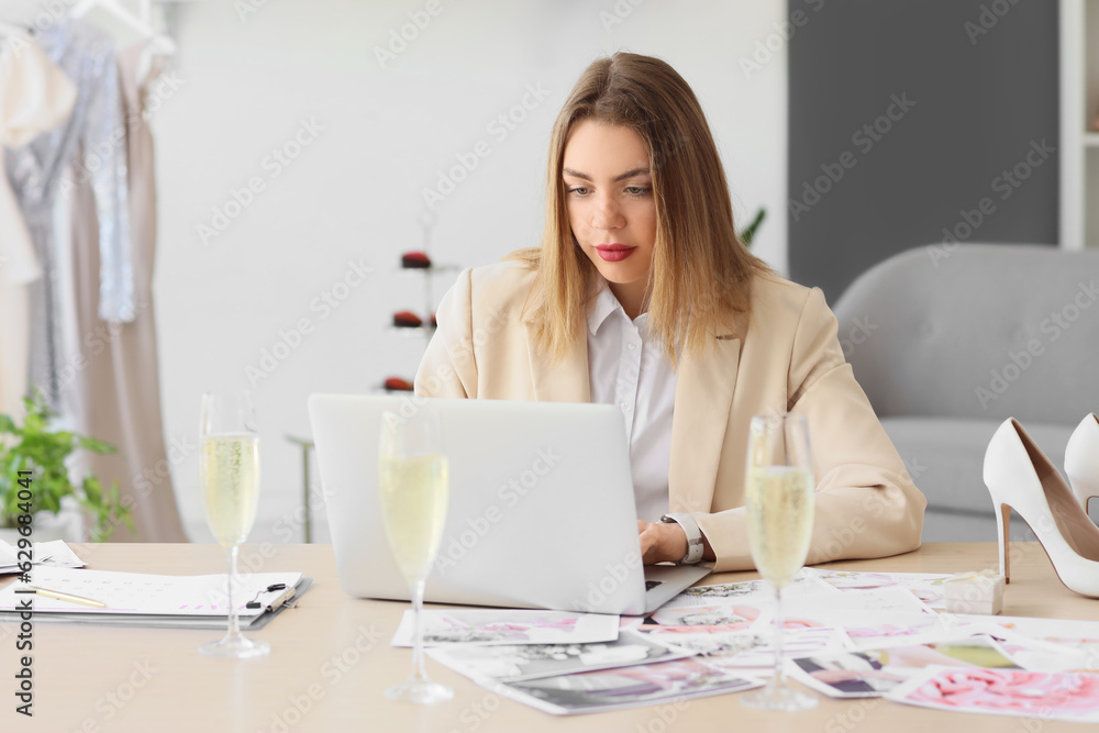 Female wedding planner working with laptop at table in office