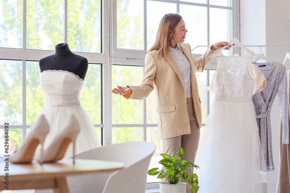 Female wedding planner with dress in office