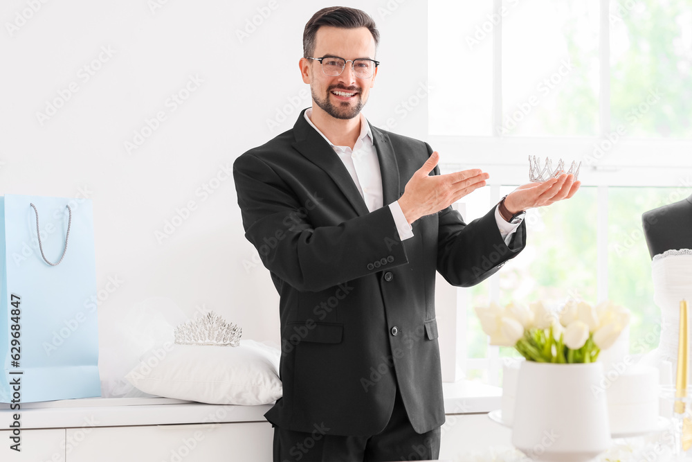 Male wedding planner with crown in office