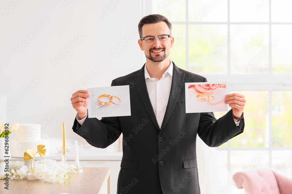 Male wedding planner with pictures of rings in office