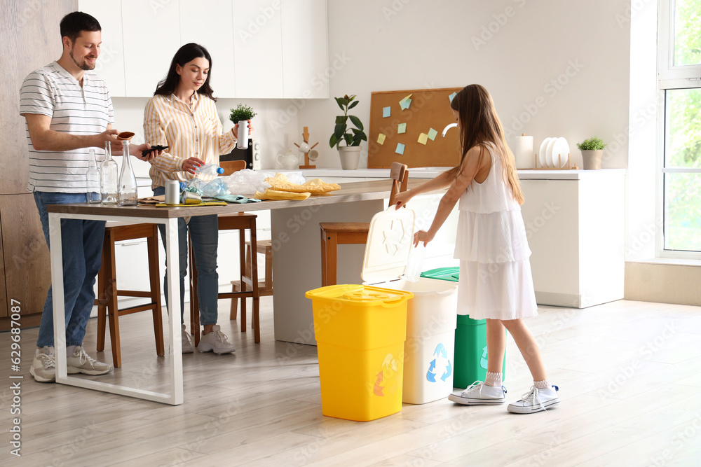 Family sorting garbage with recycle bins in kitchen