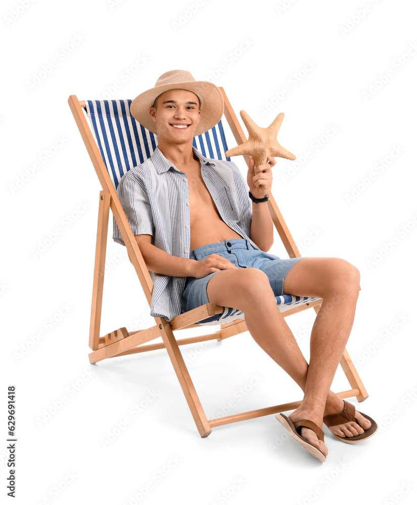 Teenage boy with starfish in deck chair on white background