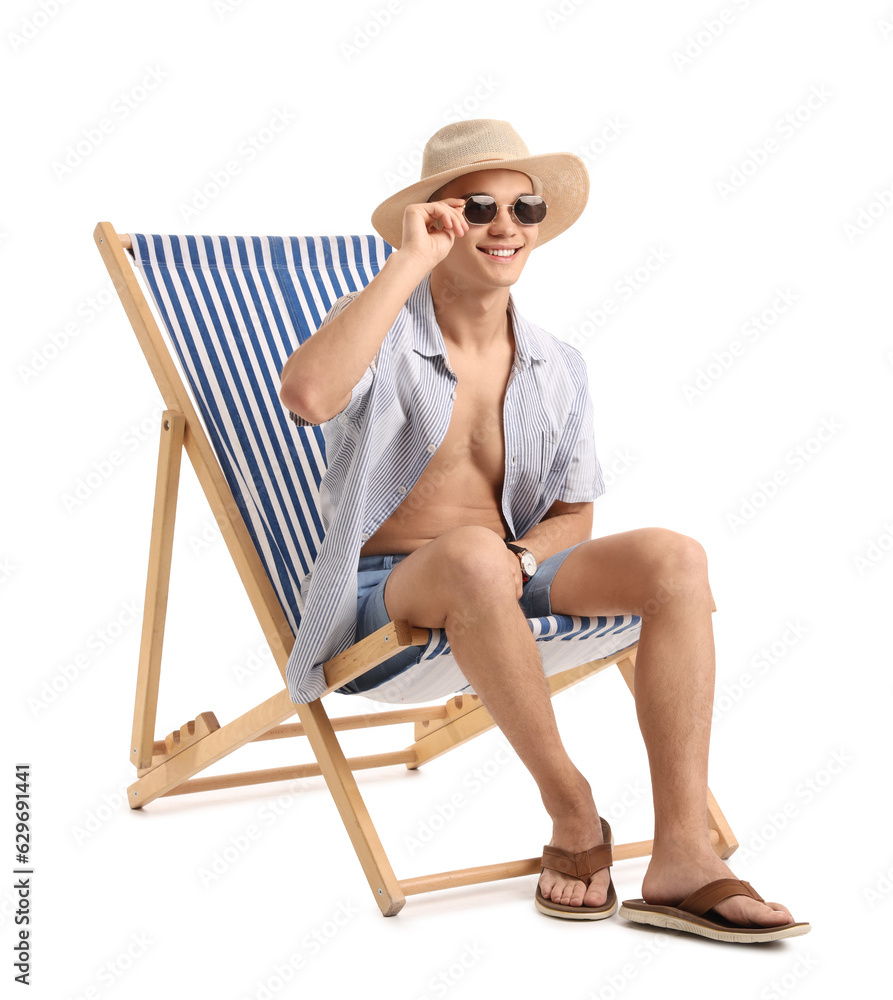 Teenage boy in deck chair on white background