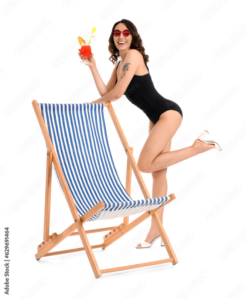 Young woman with cocktail and deck chair on white background