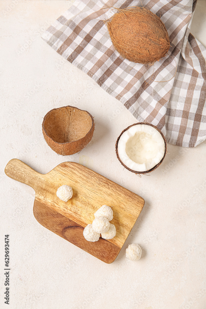 Board with white chocolate candies and coconut on light table