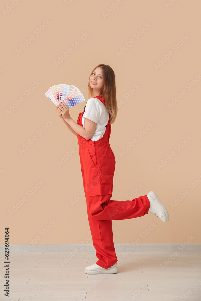 Female decorator with color samples on beige background