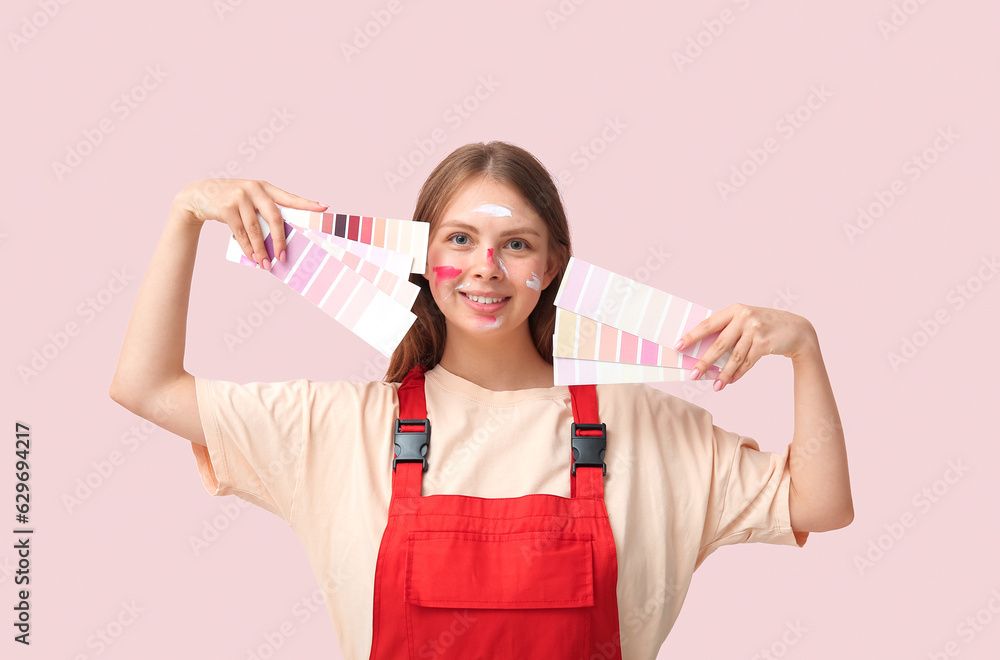 Female decorator with color samples on pink background