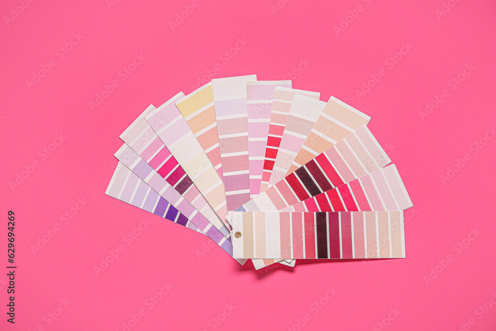 Many color palettes on pink background, top view