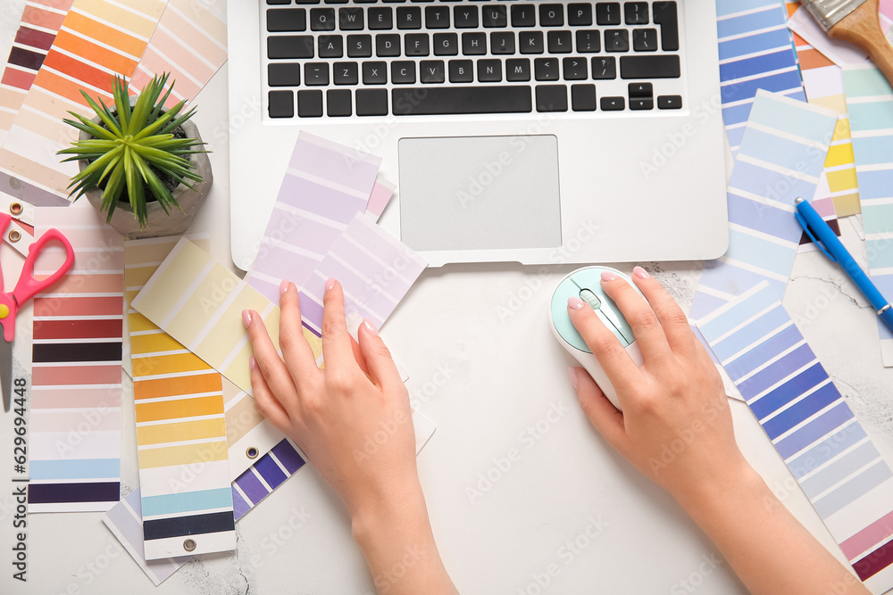 Female hands, color palettes and laptop on light background