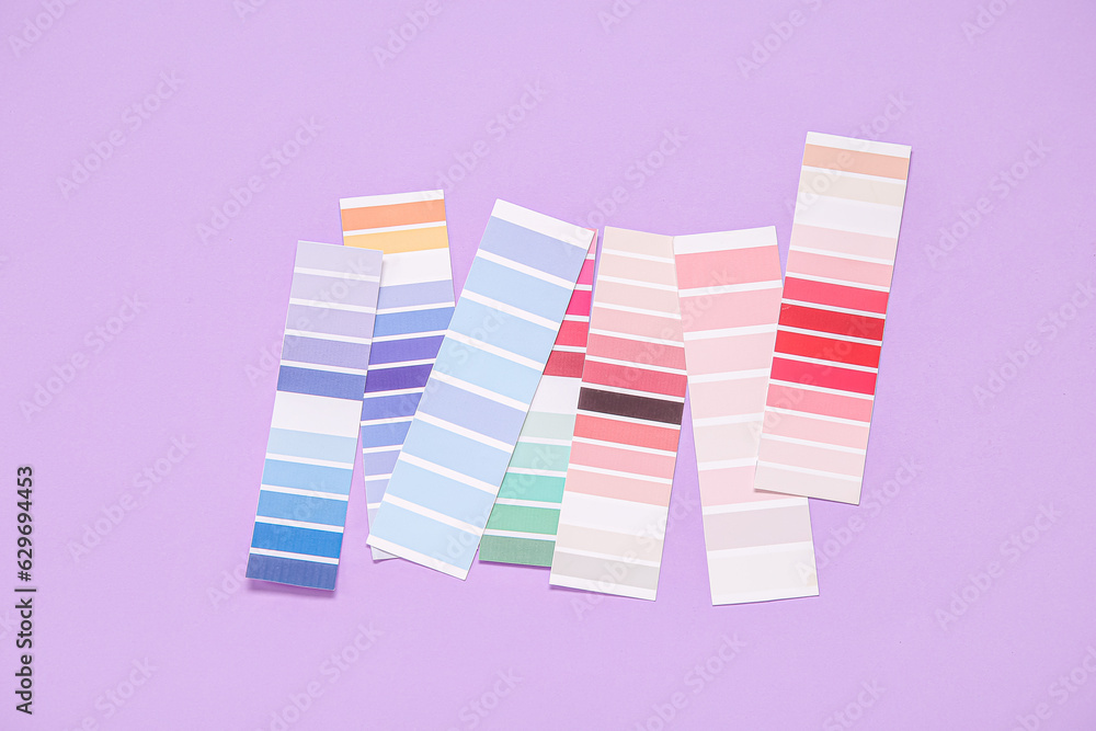 Many color palettes on lilac background, top view