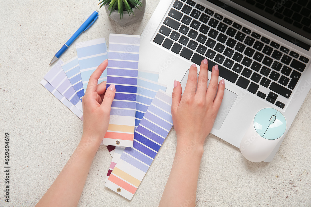 Female hands, color palettes and laptop on light background