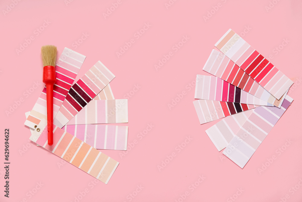 Many color palettes and brush on pink background, top view