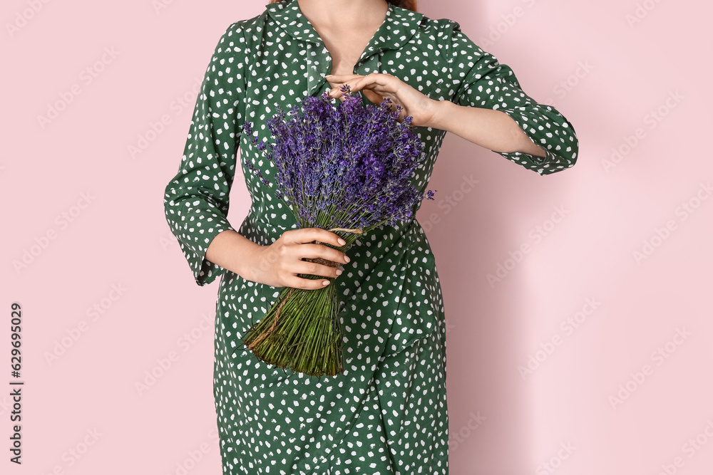 Young woman holding bouquet of beautiful lavender flowers on pink background