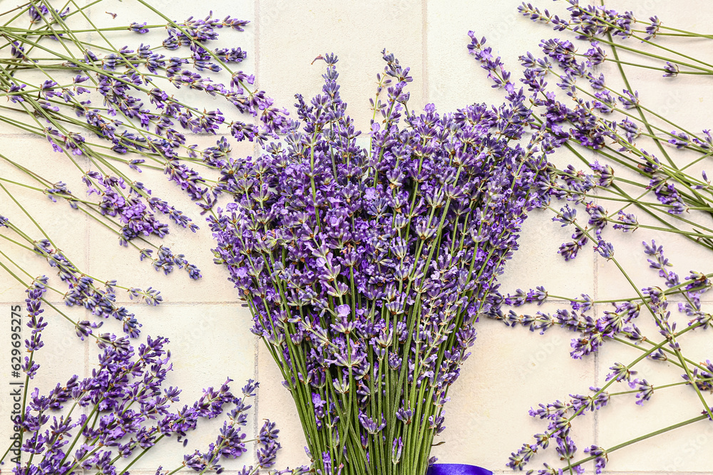 Bouquet of beautiful lavender flowers on light tile background