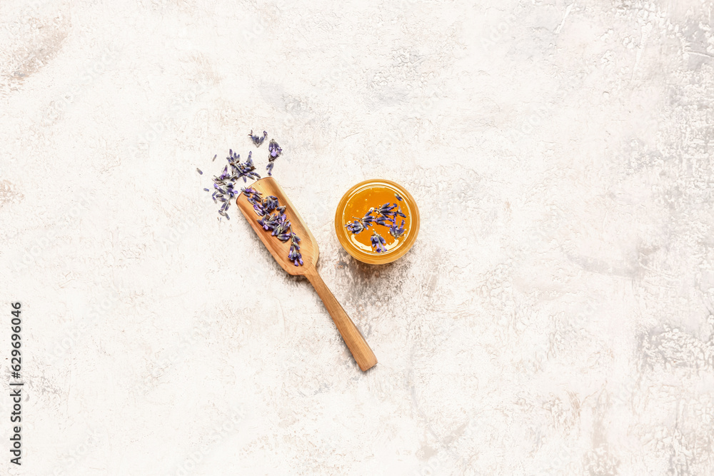 Jar of sweet lavender honey and flowers on white background