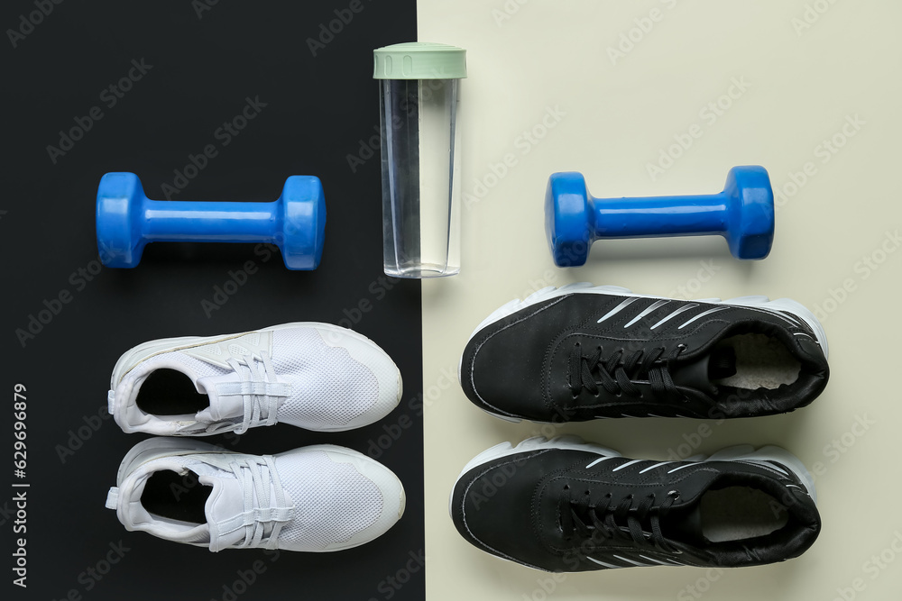 Stylish sneakers, dumbbells and bottle of water on black and white background