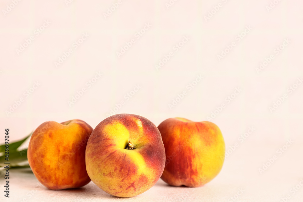 Sweet peaches and leaves on white table