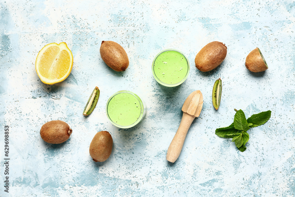 Glasses of fresh kiwi smoothie with mint and lemon on light blue background