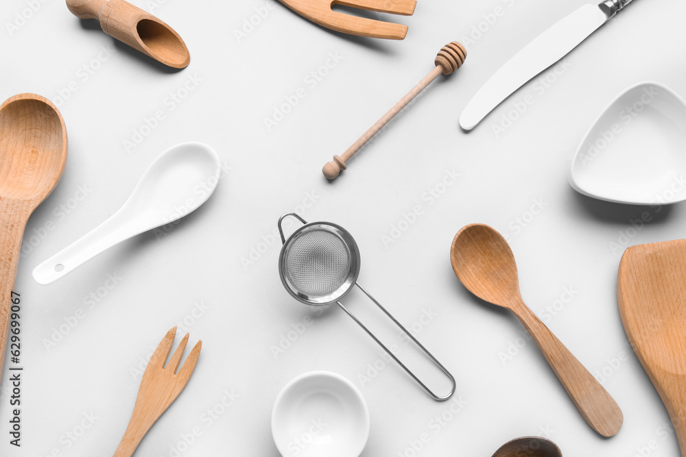 Composition with different kitchen utensils on light background