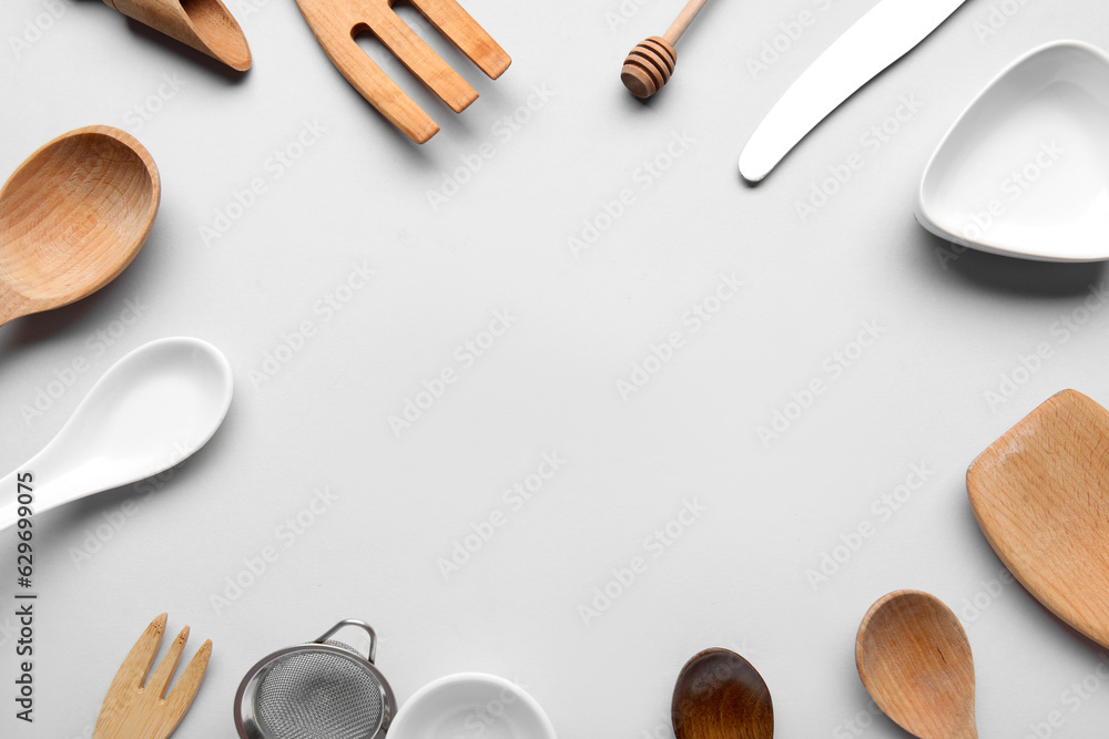 Frame made of different kitchen utensils on light background