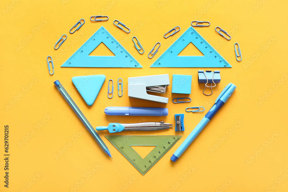 Different school stationery in shape of heart on orange background