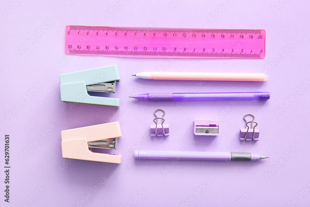 Different school stationery on purple background