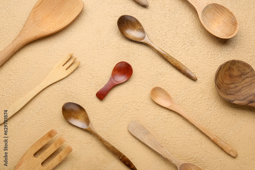 Set of wooden kitchen utensils on color background