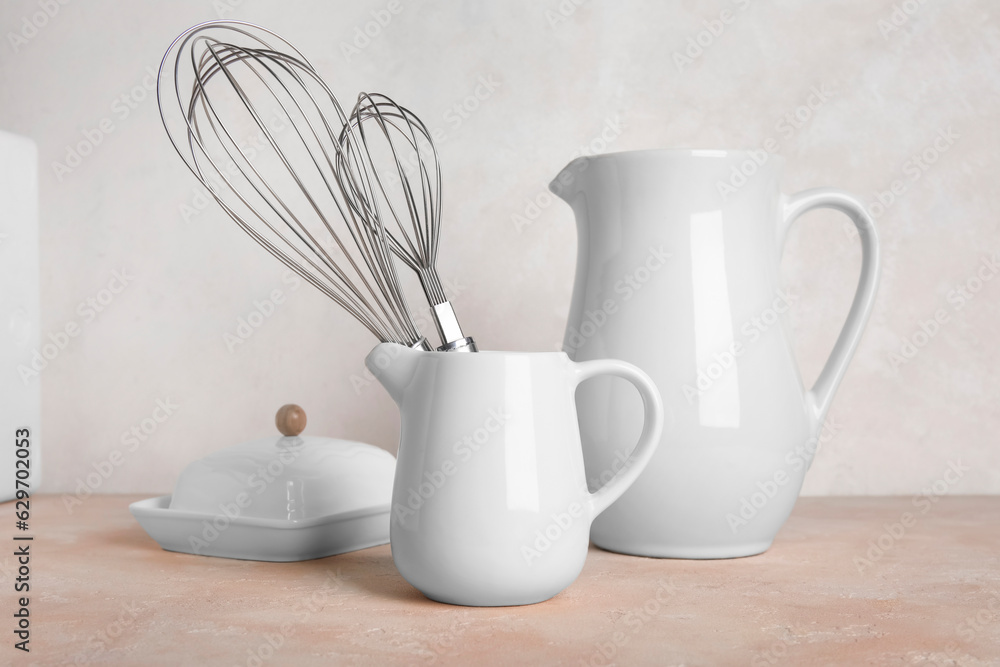 Set of different kitchen utensils on color table against light background