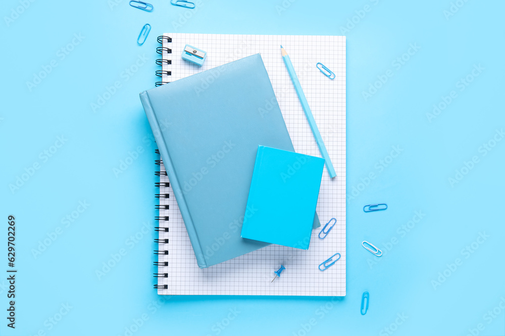 Set of stationery with notebooks on blue background